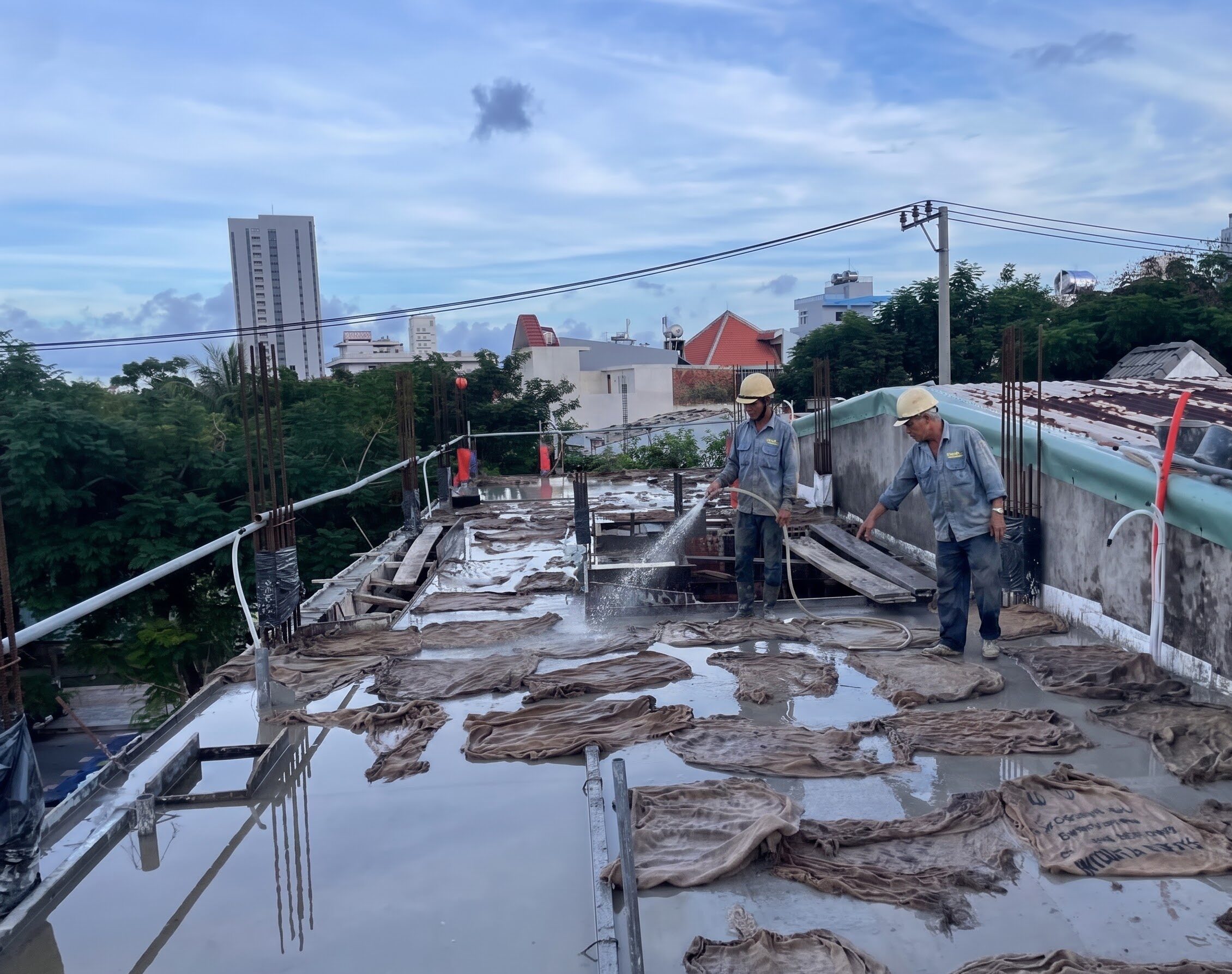 công nhân thực hiện bảo dưỡng bê tông tại công trình